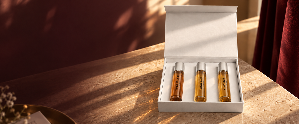 INKÛNU Travel Set — three 15 ml perfumes in their open white case, in warm evening light
